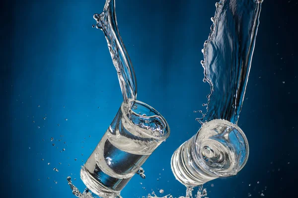 Óculos Caindo Com Vodka Spray Fundo Azul — Fotografia de Stock