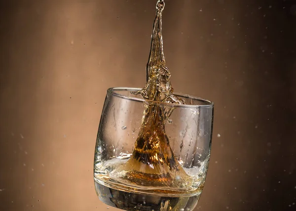 Falling Glass Whiskey Spray Brown Background — Stock Photo, Image