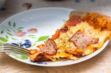 Evde servis edilen pizzalar, arka planda yemek yemek.