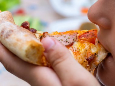 Evde servis edilen pizzalar, arka planda yemek yemek.