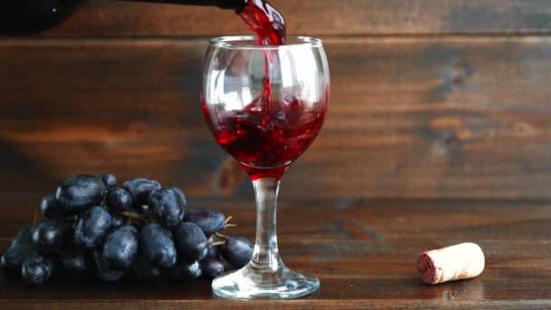 Versare Vino Rosso Bicchiere Accanto All Uva Uno Sfondo Legno — Video Stock