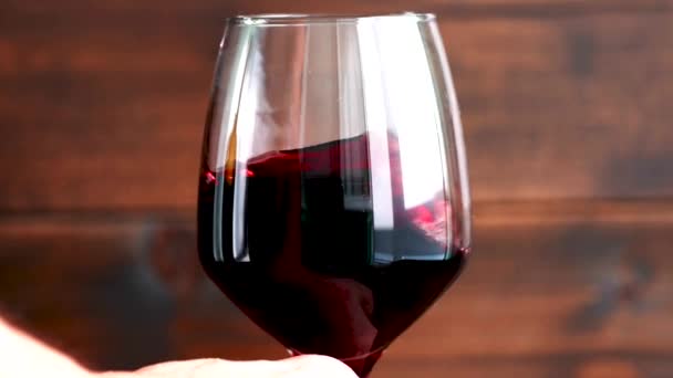 木の背景に赤ワインをブドウの隣のガラスに注ぐと — ストック動画