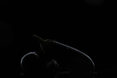 Siyah arka planda patlıcan ve damla damla su.