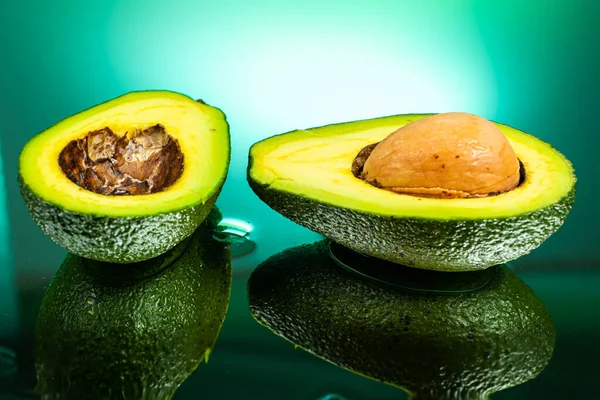 Gesneden Avocado Tweeën Met Bot Binnen Met Spetterend Water Gradiënt — Stockfoto