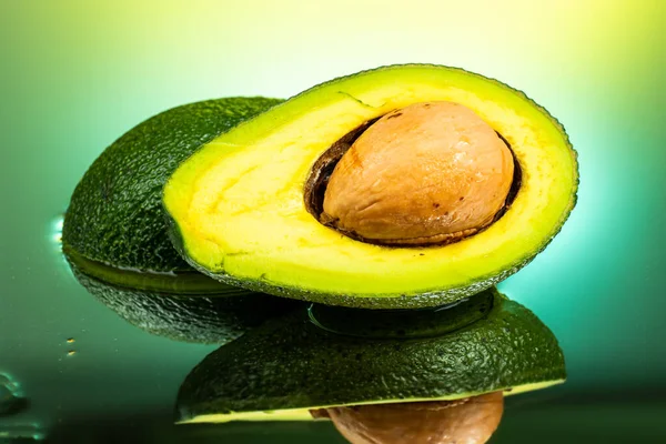 Gesneden Avocado Tweeën Met Bot Binnen Met Spetterend Water Gradiënt — Stockfoto