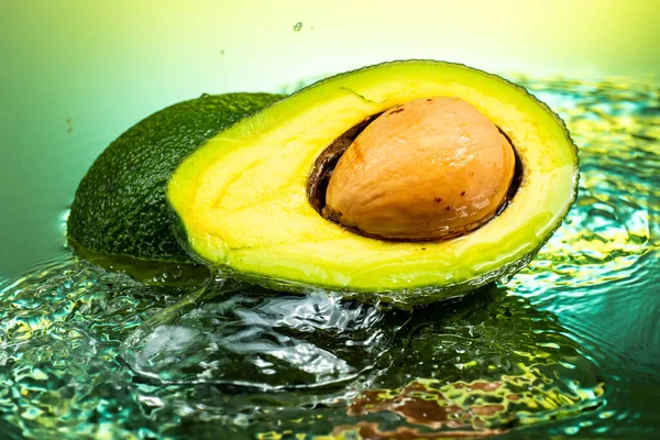 Gesneden Avocado Tweeën Met Bot Binnen Met Spetterend Water Gradiënt — Stockfoto