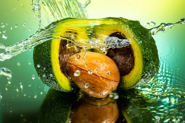 Gesneden Avocado Tweeën Met Bot Binnen Met Spetterend Water Gradiënt — Stockfoto