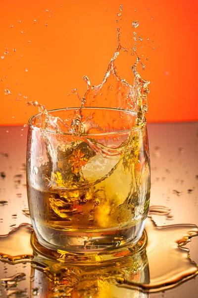 Whiskey Con Hielo Salpicado Vaso Sobre Fondo Degradado Color —  Fotos de Stock