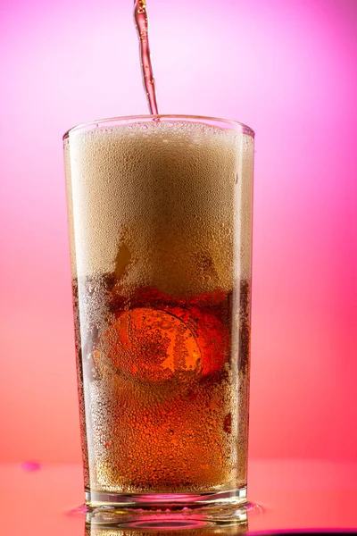 Versare Cola Bicchiere Con Pezzi Ghiaccio Puro Uno Sfondo Rosso — Foto Stock