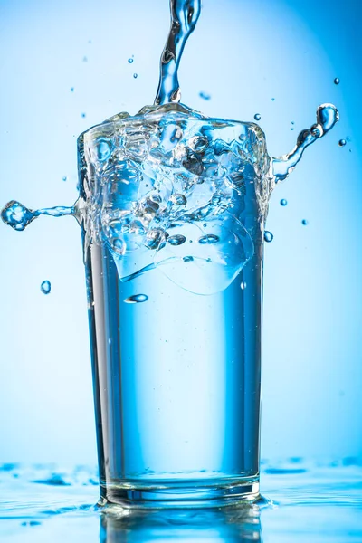 Вылить Чистую Воду Стакан Кусочками Чистого Реального Льда Голубом Градиентном — стоковое фото