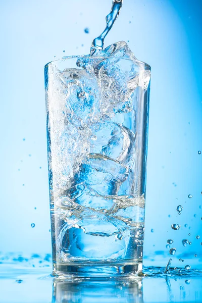 Gießen Sie Klares Wasser Ein Glas Mit Reinen Eisstücken Auf Stockbild