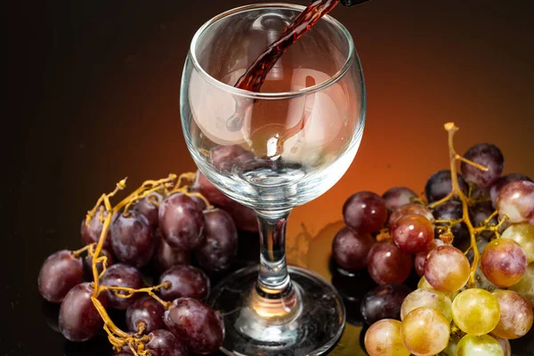 Verter Vino Tinto Vaso Pie Junto Las Uvas Sobre Fondo — Foto de Stock