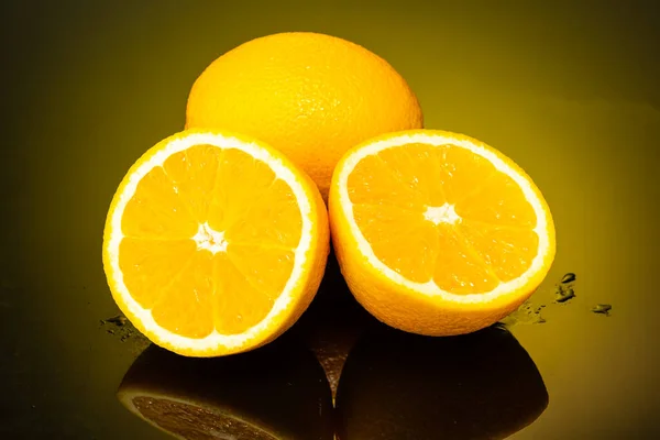 Δύο Πορτοκάλια Ολόκληρα Και Κομμένα Στη Μέση Σταγόνες Και Πιτσιλιές — Φωτογραφία Αρχείου