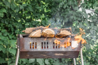 Mangal için yakacak odun hazırlanması. Ahşap doğa arka plan üzerinde yanan ile barbekü. Yanan odun.