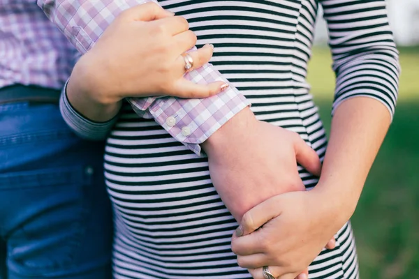 Future dad hugs his wife\'s pregnant tummy