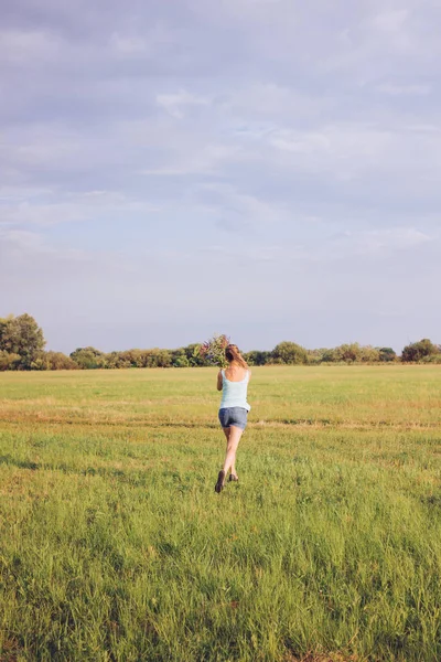 Дівчина в полі з букетом — стокове фото