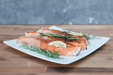 Beyaz plaka ve biberiye taze çiğ kırmızı balık fileto. yakın çekim