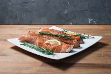 Beyaz plaka ve biberiye taze çiğ kırmızı balık fileto. yakın çekim