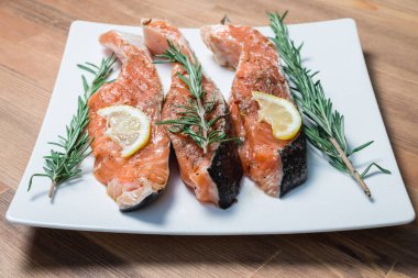 Beyaz plaka ve biberiye taze çiğ kırmızı balık fileto. yakın çekim