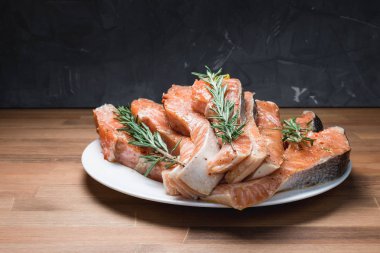 Beyaz plaka ve biberiye taze çiğ kırmızı balık fileto. yakın çekim.