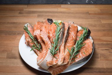 Beyaz plaka ve biberiye taze çiğ kırmızı balık fileto. yakın çekim. üstten görünüm