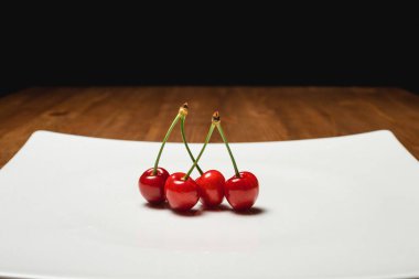 Taze kiraz ahşap mavi zemin üzerine plaka üzerinde. taze olgun kiraz. tatlı kiraz. Yakın çekim