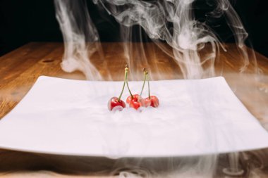 beyaz bir tabak ve soars buzda taze kiraz bırakır. yakın çekim