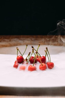 beyaz bir tabak ve soars buzda taze kiraz bırakır. yakın çekim