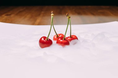 beyaz bir tabak ve soars buzda taze kiraz bırakır. yakın çekim