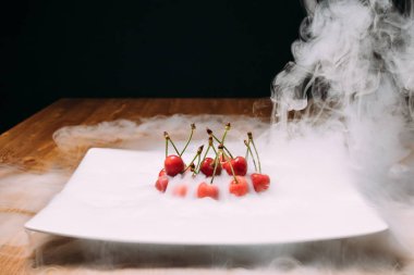 beyaz bir tabak ve soars buzda taze kiraz bırakır. yakın çekim