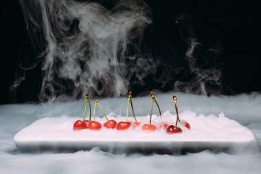 Taze kiraz bir siyah arka plan ve soar üzerinde Ice yalan. yakın çekim