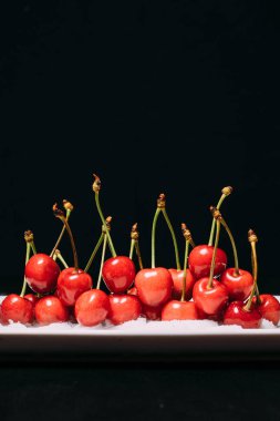 Taze kiraz ahşap mavi zemin üzerine plaka üzerinde. taze olgun kiraz. tatlı kiraz. Yakın çekim