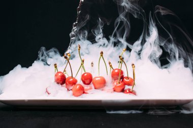 Taze kiraz bir siyah arka plan ve soar üzerinde Ice yalan. yakın çekim