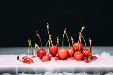 Taze kiraz bir siyah arka plan ve soar üzerinde Ice yalan. yakın çekim