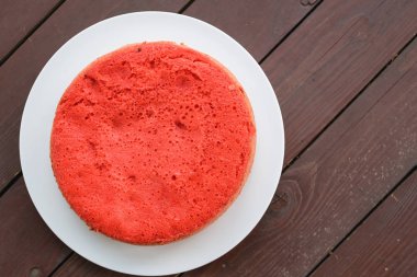 ahşap arka plan üzerinde beyaz bir plaka üzerinde kırmızı bisküvi ayakta. büyük plan, üstten görünüm. kopya alanı