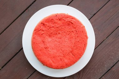 ahşap arka plan üzerinde beyaz bir plaka üzerinde kırmızı bisküvi ayakta. büyük plan, üstten görünüm. kopya alanı