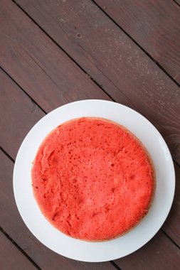 ahşap arka plan üzerinde beyaz bir plaka üzerinde kırmızı bisküvi ayakta. büyük plan, üstten görünüm. kopya alanı