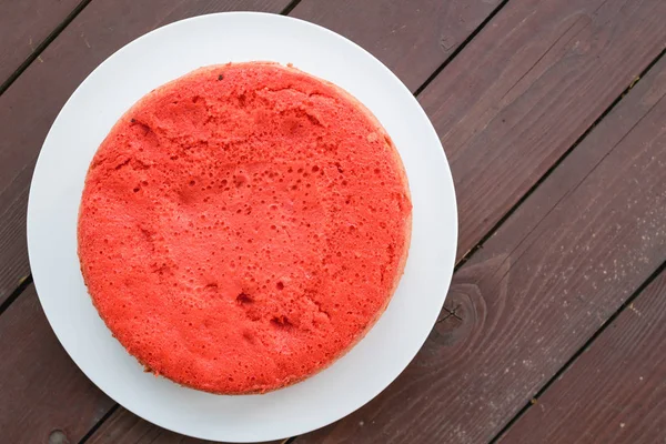 ahşap arka plan üzerinde beyaz bir plaka üzerinde kırmızı bisküvi ayakta. büyük plan, üstten görünüm. kopya alanı