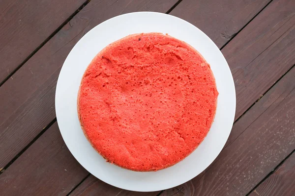 ahşap arka plan üzerinde beyaz bir plaka üzerinde kırmızı bisküvi ayakta. büyük plan, üstten görünüm. kopya alanı