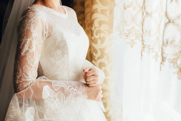 A noiva em um vestido bonito está de pé perto da janela. Fecha. espaço de cópia . — Fotografia de Stock