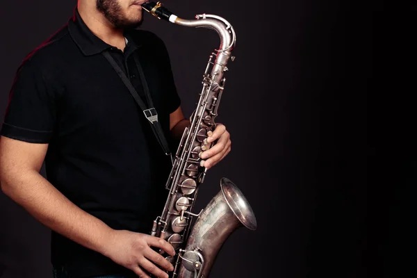 Genç adam saksafon çalıyor. Kapat.