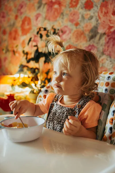 cute baby girl eating food on kitchen