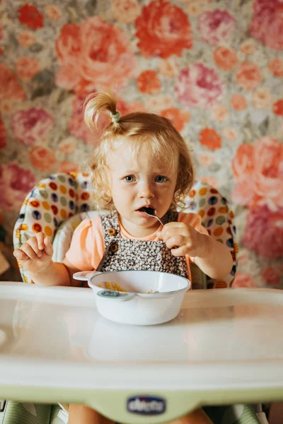 cute baby girl eating food on kitchen