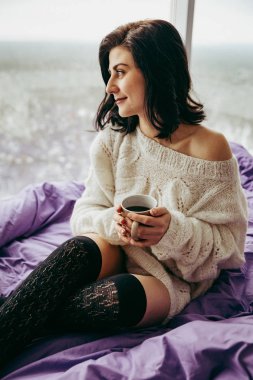 pencerenin yanında otururken sabah çay içme genç esmer kadın 