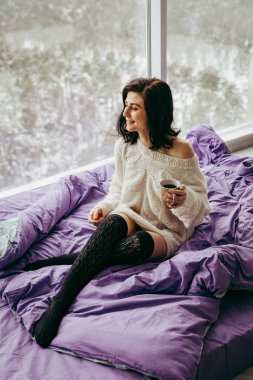 pencerenin yanında otururken sabah çay içme genç esmer kadın 