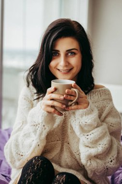 pencerenin yanında otururken sabah çay içme genç esmer kadın 