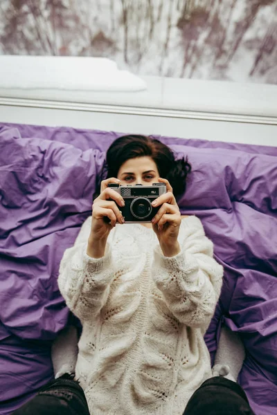 young brunette woman with retro camera