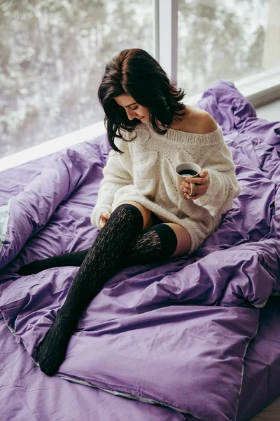 pencerenin yanında otururken sabah çay içme genç esmer kadın 