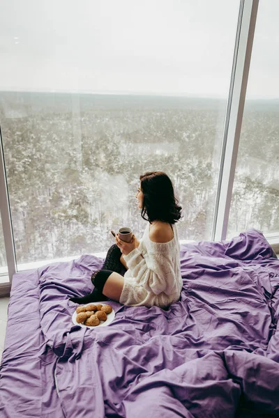 Joven Morena Bebiendo Café Comiendo Galletas Mientras Está Sentada Cerca — Foto de Stock