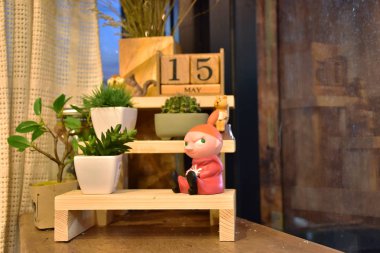 Kahve Cafe bir köşede dekore edilmiş bir dall, mini ağaçları, ahşap raf tarafından akşam masada, bunlar.